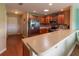 Well-lit kitchen with modern appliances, stone countertops, wood cabinets, and wood flooring at 16215 Sw 15Th Ct, Ocala, FL 34473