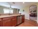 Bright kitchen features wood cabinets, stainless steel dishwasher, and an open view to the living area at 16215 Sw 15Th Ct, Ocala, FL 34473