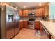 Modern kitchen featuring stainless steel appliances, wood cabinetry, tile backsplash, and countertops at 16215 Sw 15Th Ct, Ocala, FL 34473