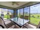 Enclosed lanai with a ceiling fan and large windows providing views of the backyard, plus an outdoor grill at 16215 Sw 15Th Ct, Ocala, FL 34473