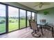 Enclosed lanai with sliding glass doors overlooking a manicured backyard and a table with seating for four at 16215 Sw 15Th Ct, Ocala, FL 34473