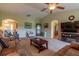 Inviting living room with plush carpet, neutral paint, ceiling fan, and views into kitchen and entry at 16215 Sw 15Th Ct, Ocala, FL 34473
