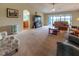 Spacious living room with plush carpeting, ceiling fan, and sliders to the outdoor patio at 16215 Sw 15Th Ct, Ocala, FL 34473