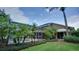 Landscaped backyard featuring mature trees, a pool, and a screened-in lanai, enhancing outdoor living at 17034 Florence View Dr, Montverde, FL 34756