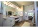 Spacious bathroom with double vanity, bench seat, walk-in closet, and decorative mirror at 17034 Florence View Dr, Montverde, FL 34756