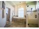 Bathroom featuring a soaking tub with chandelier, walk-in shower with seating, and tiled floor at 17034 Florence View Dr, Montverde, FL 34756