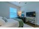 Bright bedroom with a full bed, workspace, and a decorative console table at 17034 Florence View Dr, Montverde, FL 34756