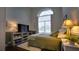 Bedroom with large window, TV, and accent wall at 17034 Florence View Dr, Montverde, FL 34756