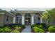 Inviting front entrance with arched windows, columns, mature landscaping, and a walkway leading to the front door at 17034 Florence View Dr, Montverde, FL 34756