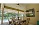 Screened-in lanai with ceiling fan and dining table overlooking the pool and green backyard at 17034 Florence View Dr, Montverde, FL 34756