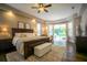 Bright main bedroom featuring hardwood floors, large bed, and sliding door access to the backyard at 17034 Florence View Dr, Montverde, FL 34756
