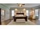 Spacious main bedroom with hardwood floors, ceiling fan, bench, and lots of natural light at 17034 Florence View Dr, Montverde, FL 34756