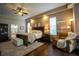Spacious main bedroom with hardwood floors, ceiling fan, sitting area, and ensuite bathroom at 17034 Florence View Dr, Montverde, FL 34756