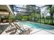 Screened in pool with palm trees and lounge chairs for relaxing in the sun at 17034 Florence View Dr, Montverde, FL 34756