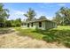 Backyard showing a green home with an expansive lawn and mature trees at 1708 Nw 27Th Ave, Ocala, FL 34475