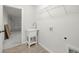 Functional laundry room with a utility sink, tile floors, and convenient access to the garage at 1708 Nw 27Th Ave, Ocala, FL 34475