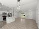 Well-lit living room and kitchen featuring modern fixtures, wood-look tile flooring, and white color palette at 1708 Nw 27Th Ave, Ocala, FL 34475