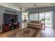 Cozy living room features a large TV, a comfortable couch, and sliding glass doors to the lanai at 1768 Sw 156Th Ln, Ocala, FL 34473