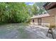 View of the backyard, with lush trees and a charming brick home exterior with a patio at 19130 Nw 60Th Ave, Reddick, FL 32686