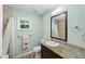 Bright bathroom featuring a granite countertop, wood-look flooring, and a shower-tub combo at 19130 Nw 60Th Ave, Reddick, FL 32686