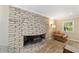 Living room featuring a stone fireplace and a seating area at 19130 Nw 60Th Ave, Reddick, FL 32686