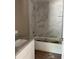 Bathroom featuring marble tile walls, a white vanity with granite countertop, and a modern bathtub at 19622 Sw Marine Blvd, Dunnellon, FL 34431