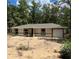 New construction home with neutral paint, dark trim, and attached one-car garage in a wooded setting at 20769 Sw Oriole Dr, Dunnellon, FL 34431