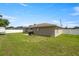 Spacious backyard featuring a well-maintained lawn, white fence, and mature trees at 28 Hemlock Radial Loop, Ocala, FL 34472