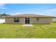 Large, grassy backyard with patio, sliding glass door and white fence in a residential neighborhood at 28 Hemlock Radial Loop, Ocala, FL 34472