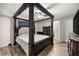 Bedroom with a four-post bed, ceiling fan, wood-look flooring, and two doors to other rooms at 28 Hemlock Radial Loop, Ocala, FL 34472