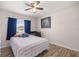 Bedroom features a ceiling fan, wood-look floors, and a bed with striped bedding at 28 Hemlock Radial Loop, Ocala, FL 34472