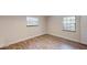 Bright bedroom featuring hardwood floors, two windows with blinds, and neutral paint at 4121 Sw 6Th Ave, Ocala, FL 34471