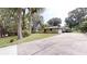 View of home showcasing an expansive driveway and lush greenery surrounding the charming property at 4121 Sw 6Th Ave, Ocala, FL 34471