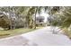 View of the home showcasing an expansive driveway and lush greenery surrounding the charming property at 4121 Sw 6Th Ave, Ocala, FL 34471