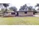 Charming single-story home with brick accents and a well-manicured front lawn surrounded by mature trees at 4121 Sw 6Th Ave, Ocala, FL 34471