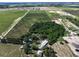 Aerial view showcases sprawling green landscape with a mix of trees and buildings under a clear sky at 4501 Detour Rd, Haines City, FL 33844