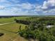 Expansive aerial view of a large, open property with lush greenery and scattered trees under a partly cloudy blue sky at 4501 Detour Rd, Haines City, FL 33844