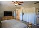 Cozy bedroom featuring a ceiling fan, built-in drawers, and a large TV at 4501 Detour Rd, Haines City, FL 33844