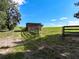 View of a grassy area with wooden fence and a small wooden structure set against a bright blue sky at 4501 Detour Rd, Haines City, FL 33844