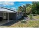 Side view of blue house with metal roof, showing a patio and partially landscaped yard at 4501 Detour Rd, Haines City, FL 33844