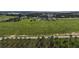 Aerial view of a large grassy field that is lined with trees, homes, and lakes, under a blue sky at 4501 Detour Rd, Haines City, FL 33844