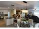 An open-concept living room features a kitchen island and contemporary chandelier for a bright, airy space at 4501 Detour Rd, Haines City, FL 33844