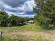 A green grass yard with an orange outbuilding and white roof under partly cloudy sky at 4501 Detour Rd, Haines City, FL 33844