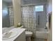 Cozy bathroom with a floral shower curtain, single sink vanity, and easy-access grab bars for convenience at 4622 Ne 15Th St, Ocala, FL 34470