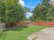 Well-maintained backyard with green grass, mature trees, and fenced perimeter at 4660 Se 142Nd Ln, Summerfield, FL 34491