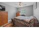 This bedroom features a ceiling fan, window, wood-look flooring, and a large wooden dresser with drawers at 4660 Se 142Nd Ln, Summerfield, FL 34491
