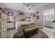 Comfortable bedroom with a ceiling fan, wood-look floors, and ensuite bath at 4660 Se 142Nd Ln, Summerfield, FL 34491