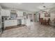 Bright kitchen with white cabinetry, granite countertops, and stainless steel appliances open to dining area at 4660 Se 142Nd Ln, Summerfield, FL 34491