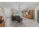 Cozy living room features wood-look tile floors, a ceiling fan, and a large window for natural light at 4660 Se 142Nd Ln, Summerfield, FL 34491