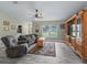 Inviting living room with wood-look tile floors, a ceiling fan, and a large window at 4660 Se 142Nd Ln, Summerfield, FL 34491